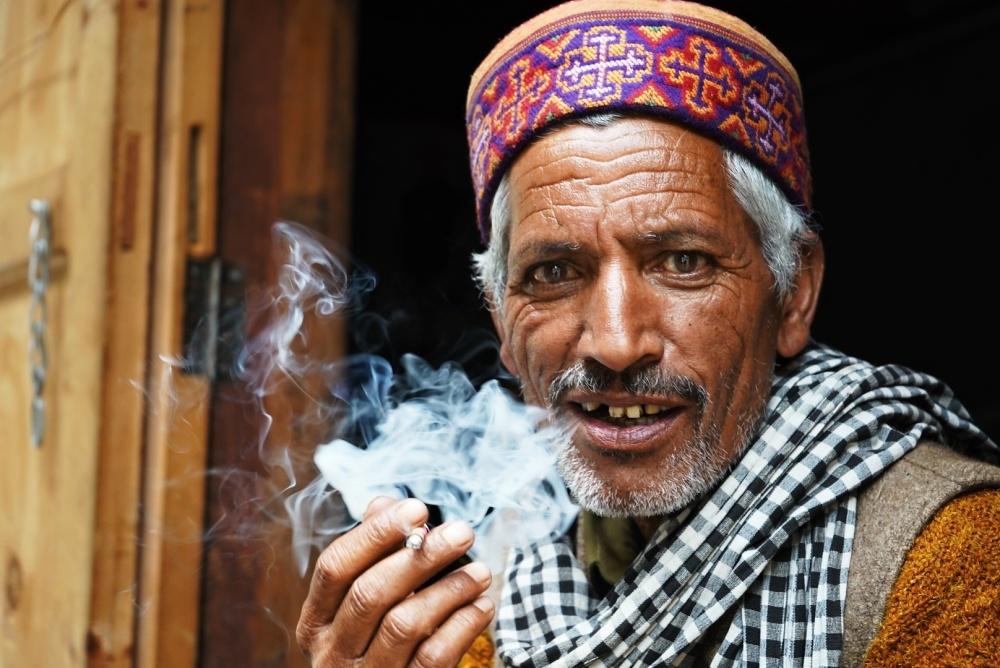 Vesničan v Kugti v klidu pokuřuje a pije čaj